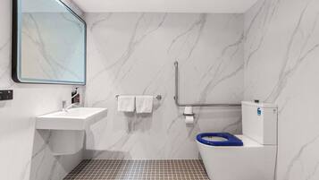 A modern bathroom with a marble wall, a sink, a toilet, and a shower area.