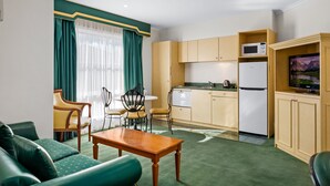A compact living space with a dining area, kitchen, and seating. - Rowville International Hotel (Rowville)