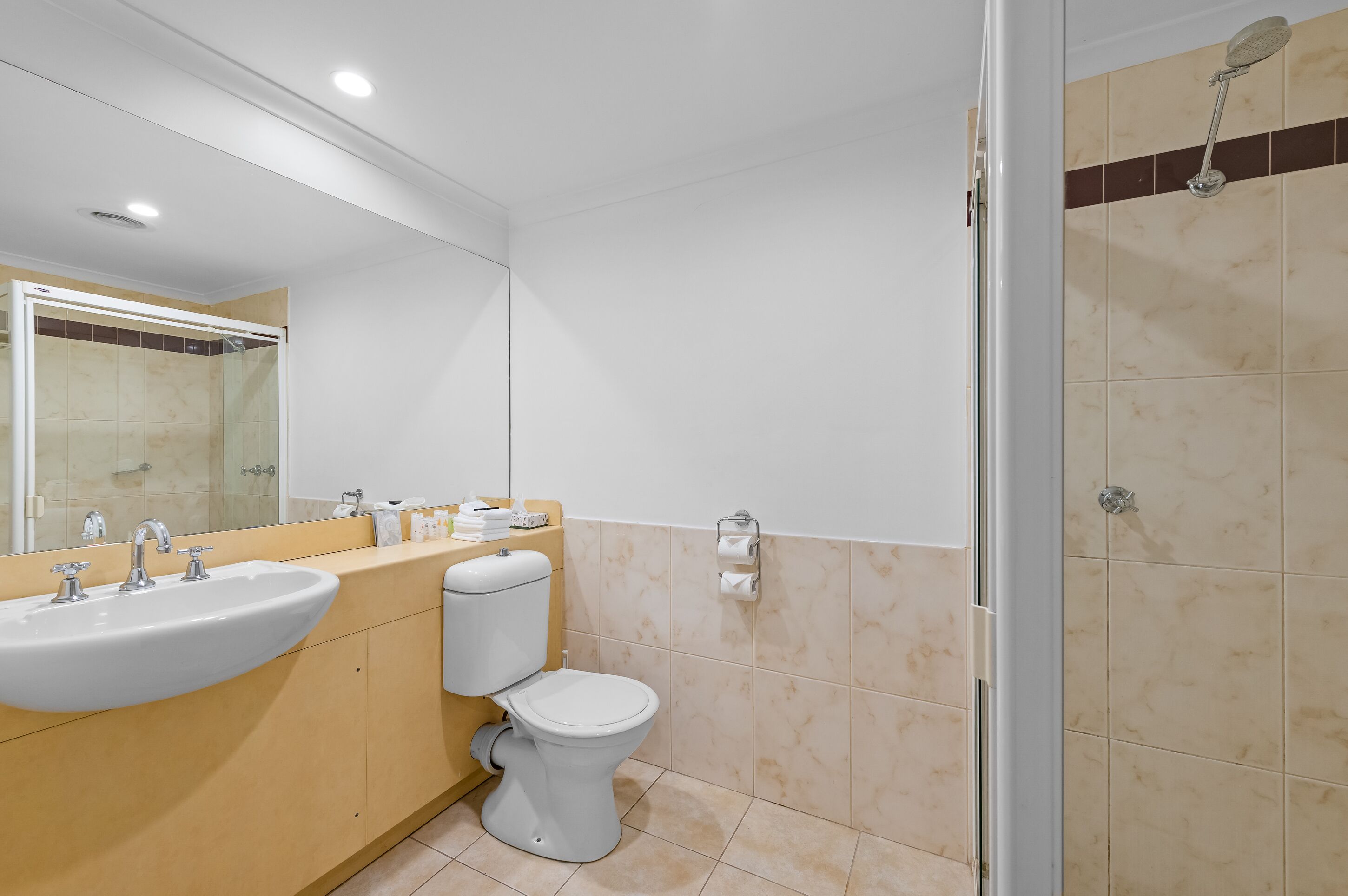 A modern bathroom with a sink, toilet, and shower.