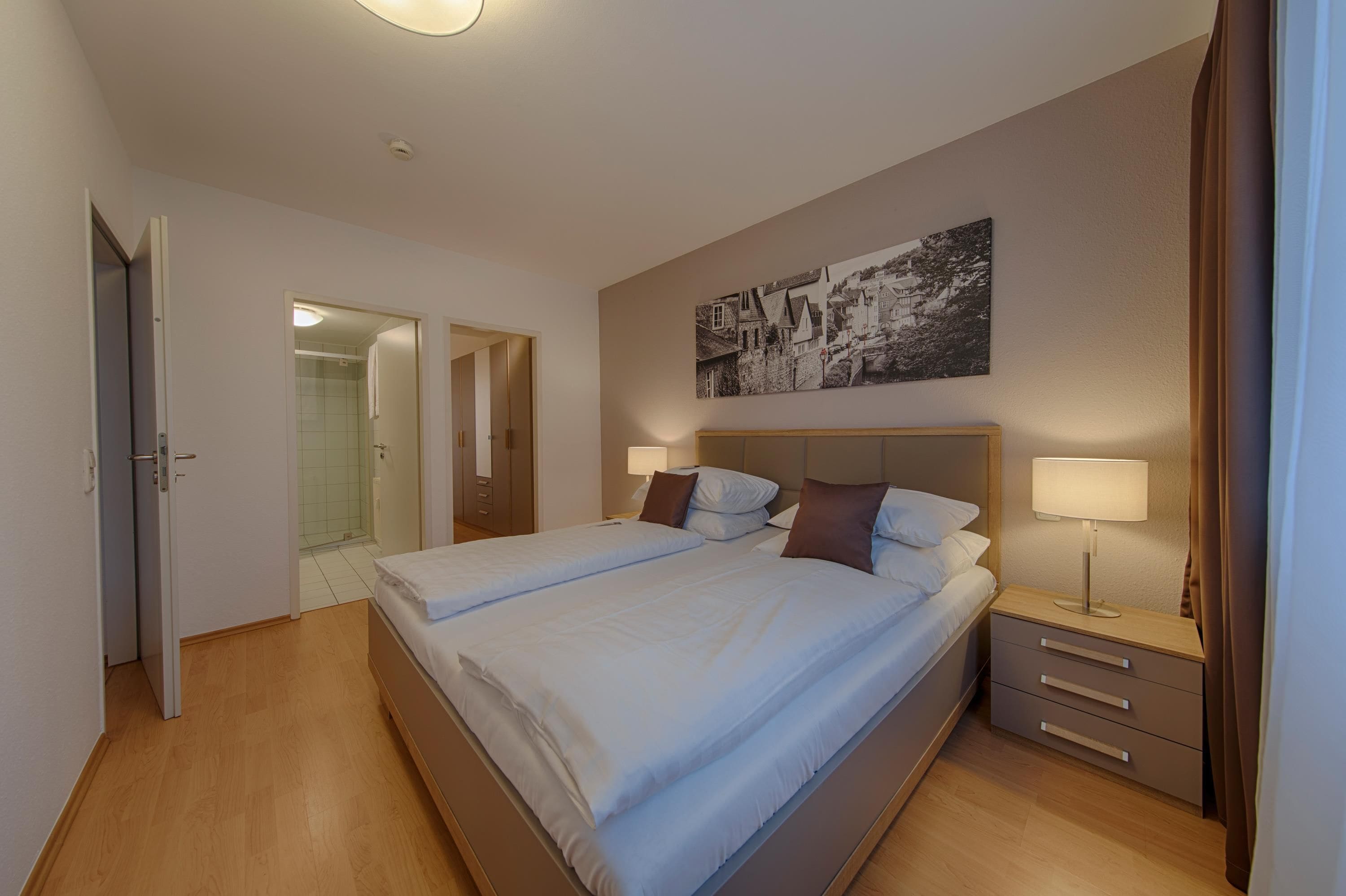 Habitación de hotel con dos camas, un baño y un pasillo.