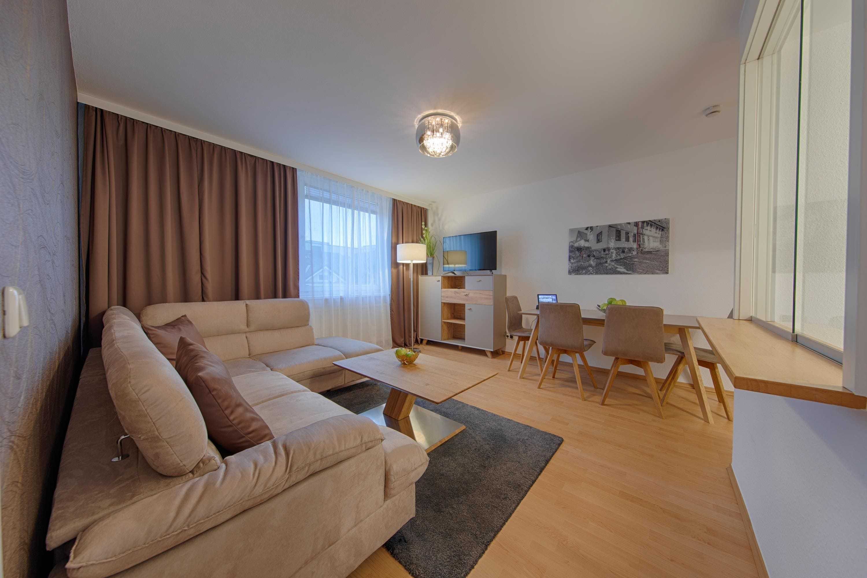 En moderne stue med sofa, sofabord og spiseplads.