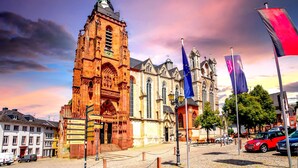 A historic building with intricate architecture, a prominent tower, and a flagpole with multiple flags. - Best Western Hotel Wetzlar (Wetzlar)