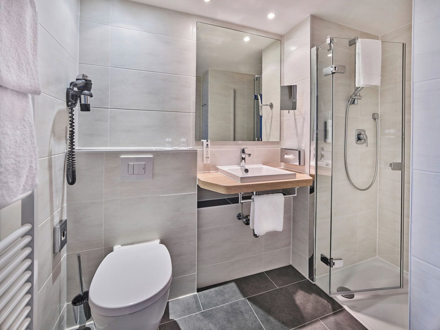 A modern bathroom with a toilet, sink, and shower.