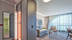 A modern hotel room with a large window, a sofa, a chair, and a small table. - Best Western Hotel Wetzlar (Wetzlar)