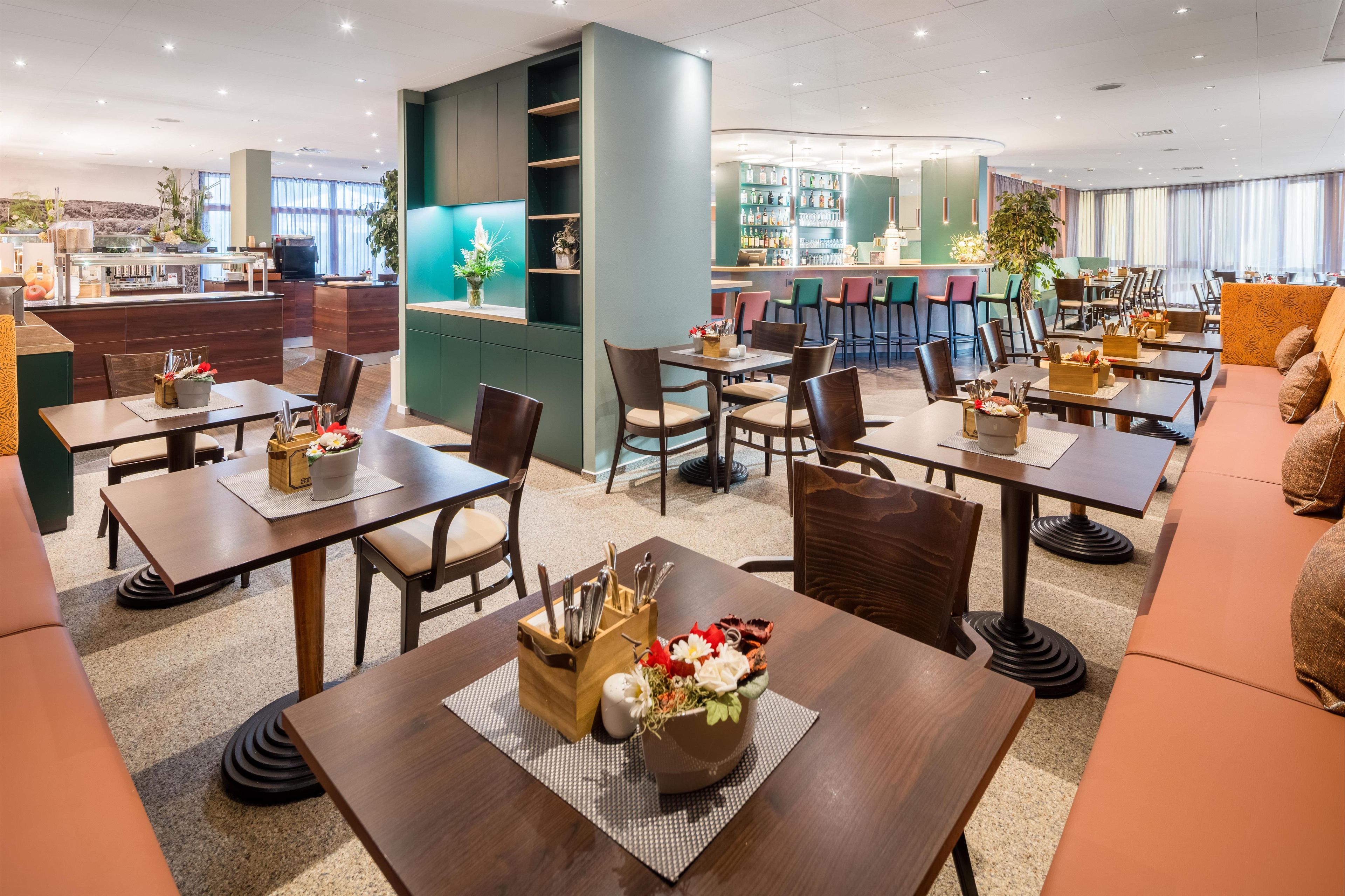 A restaurant with multiple dining tables, chairs, and a bar area.