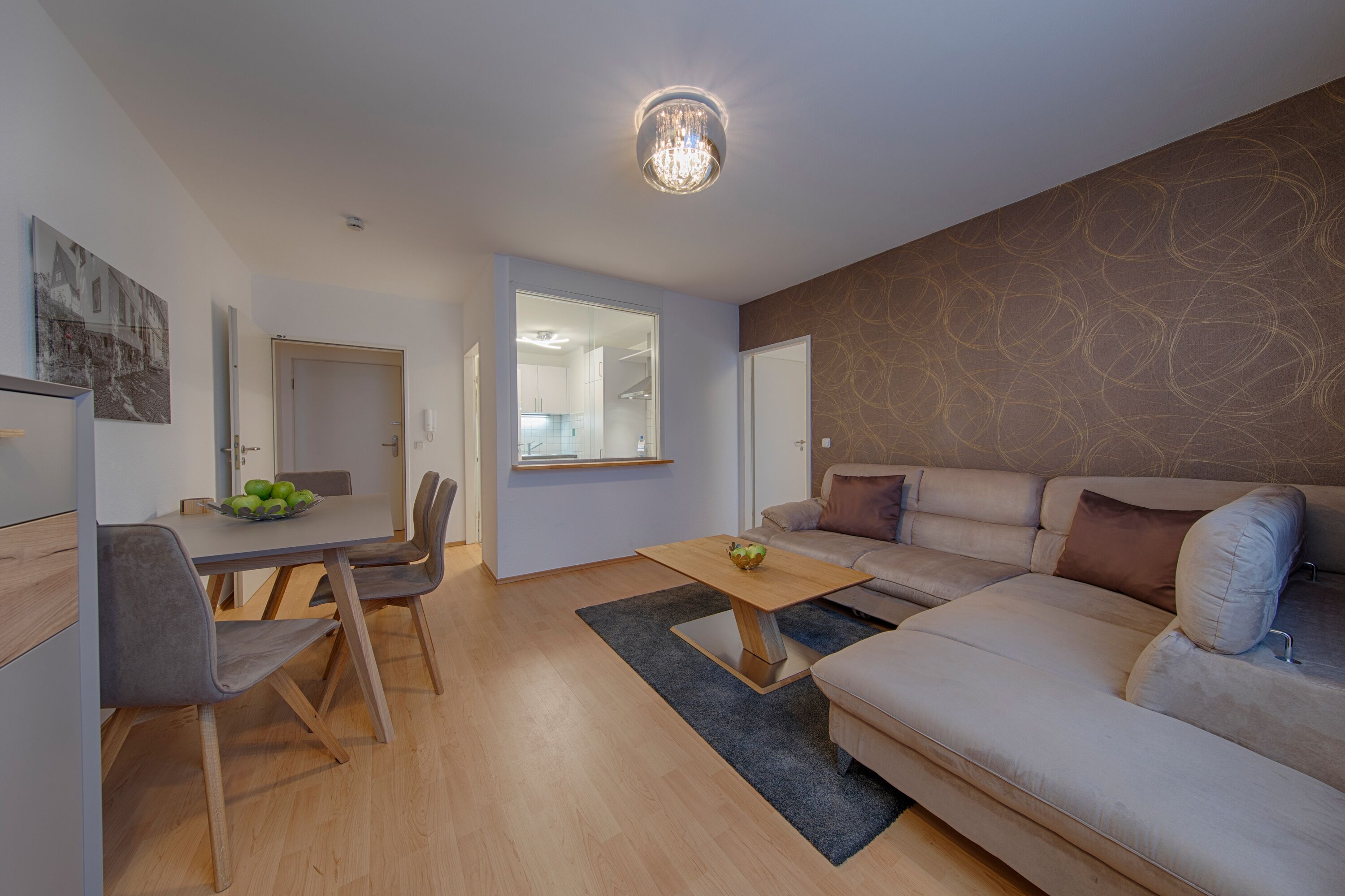 Ein modernes Wohnzimmer mit Sofa, Couchtisch und Essbereich.