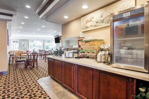Un vestíbulo de hotel con una recepción, zona de estar y un refrigerador grande.