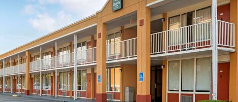 A motel with multiple balconies, a handicap-accessible entrance, and a parking lot.