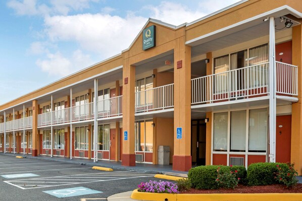 A motel with multiple balconies, a handicap-accessible entrance, and a parking lot.