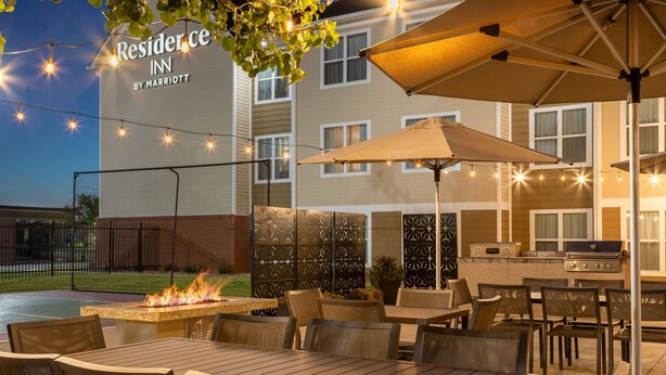En uteplats vid ett Marriott Residence Inn med utomhusmöbler, en eldstad och en grill.