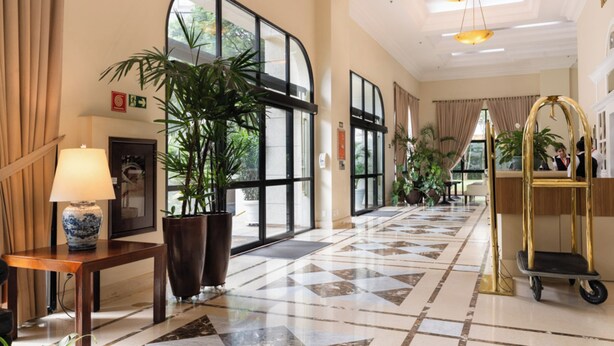 A spacious lobby with a checkered floor, large windows, and potted plants. - Intercity Pamplona - The Universe Paulista (São Paulo)