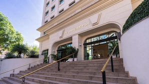 A building with a sign reading "The Universe Flat." It features a staircase with a handrail leading to the entrance. - Intercity Pamplona - The Universe Paulista (São Paulo)