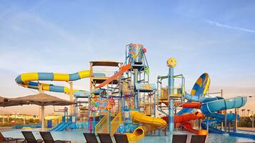 Enjoy thrilling water slides and a relaxing pool area with lounge chairs and umbrellas.