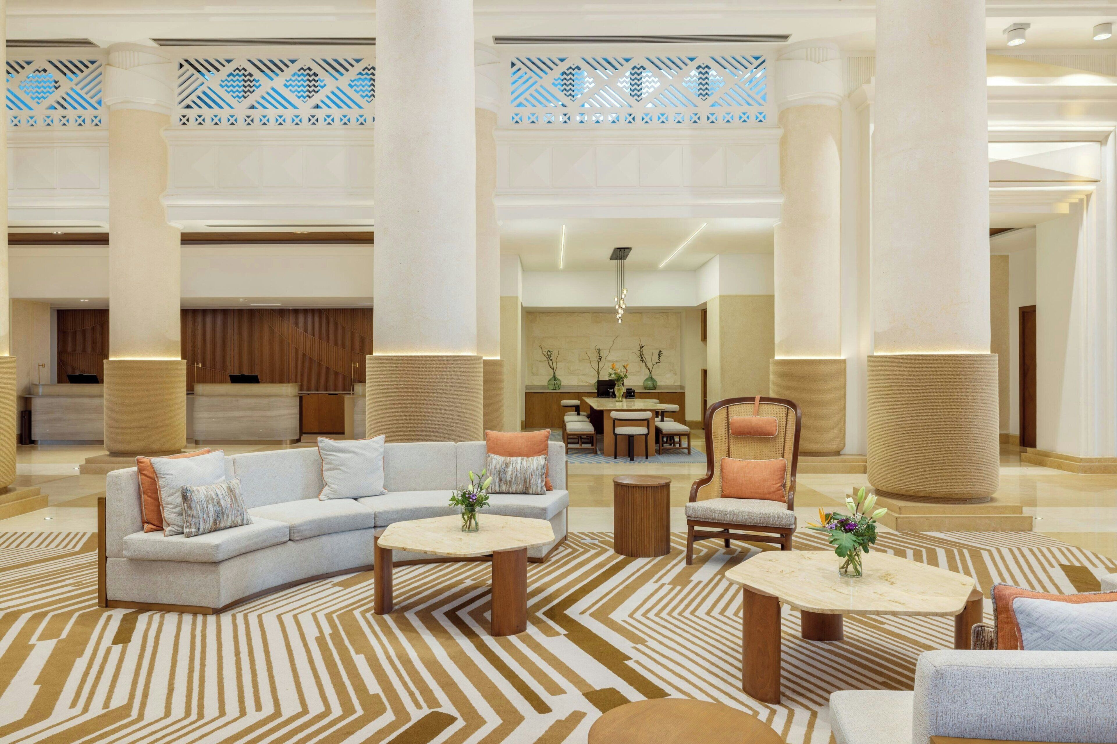 A spacious lobby with a sectional sofa, armchairs, and a coffee table.