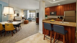 A modern kitchen with wooden cabinets, a granite countertop, and a stainless steel refrigerator.