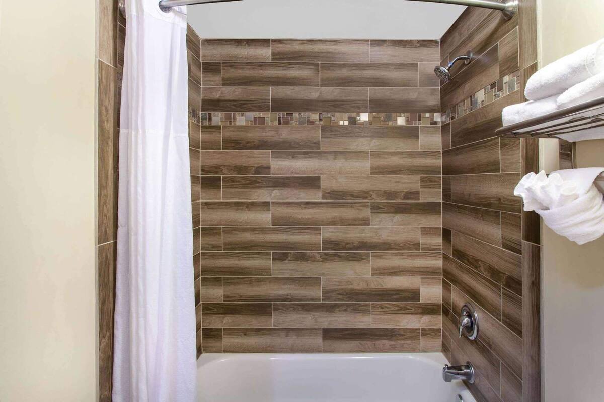 Une salle de bain avec une douche, une baignoire et un porte-serviettes.