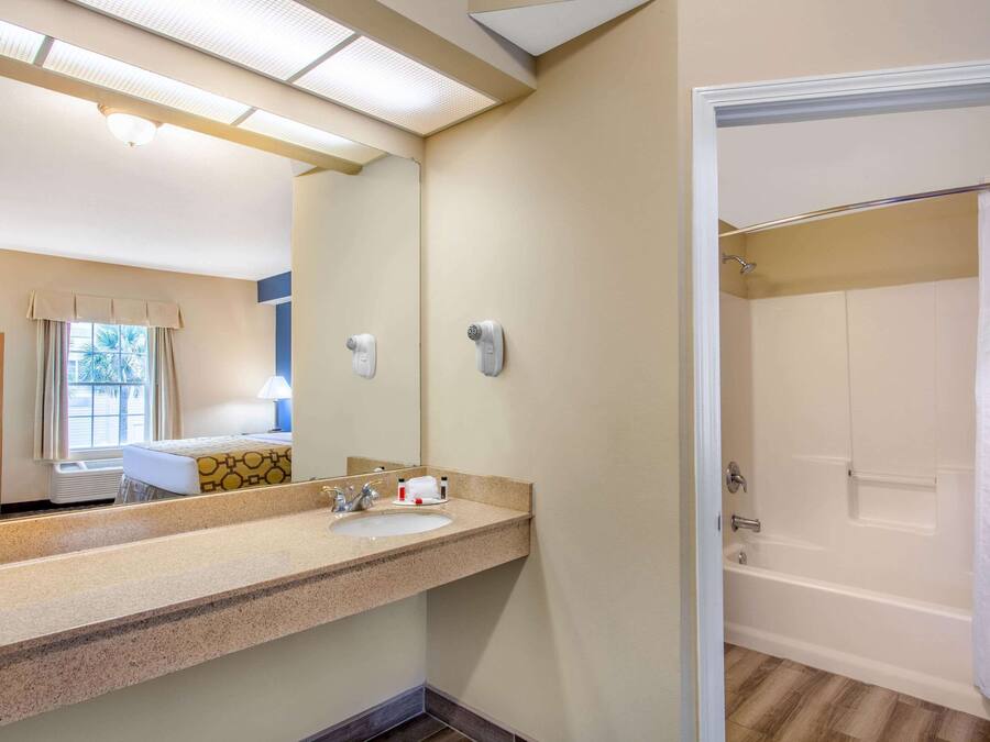 Un baño con lavabo, espejo y zona de ducha.