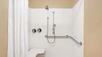 A white shower enclosure with a handheld showerhead, a handheld shower attachment, and a grab bar.