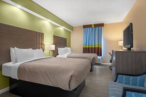 A hotel room with two beds, a television, a desk, and a chair. - Quality Inn Ormond Beach – Daytona (Ormond Beach)