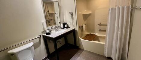 Baño con inodoro, lavamanos, espejo, ducha y bañera.