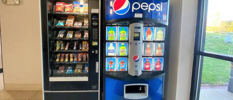 A vending machine with a Pepsi logo and a snack vending machine next to it.