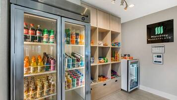Ein MainStay Marketplace mit zwei großen Kühlschränken, gefüllt mit Getränken und Snacks, sowie einem kleineren Kühlschrank.