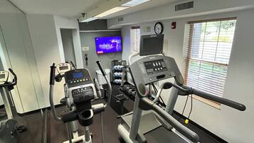 A gym with treadmills, an elliptical, and a TV displaying 'Twilight'.