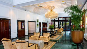 A spacious lobby with a chandelier, seating area, and a large potted plant. - Sea View Hotel, Bal Harbour, On The Ocean (Bal Harbour)