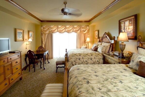 A hotel room with a large bed, a desk with a chair, a dresser, and a television.
