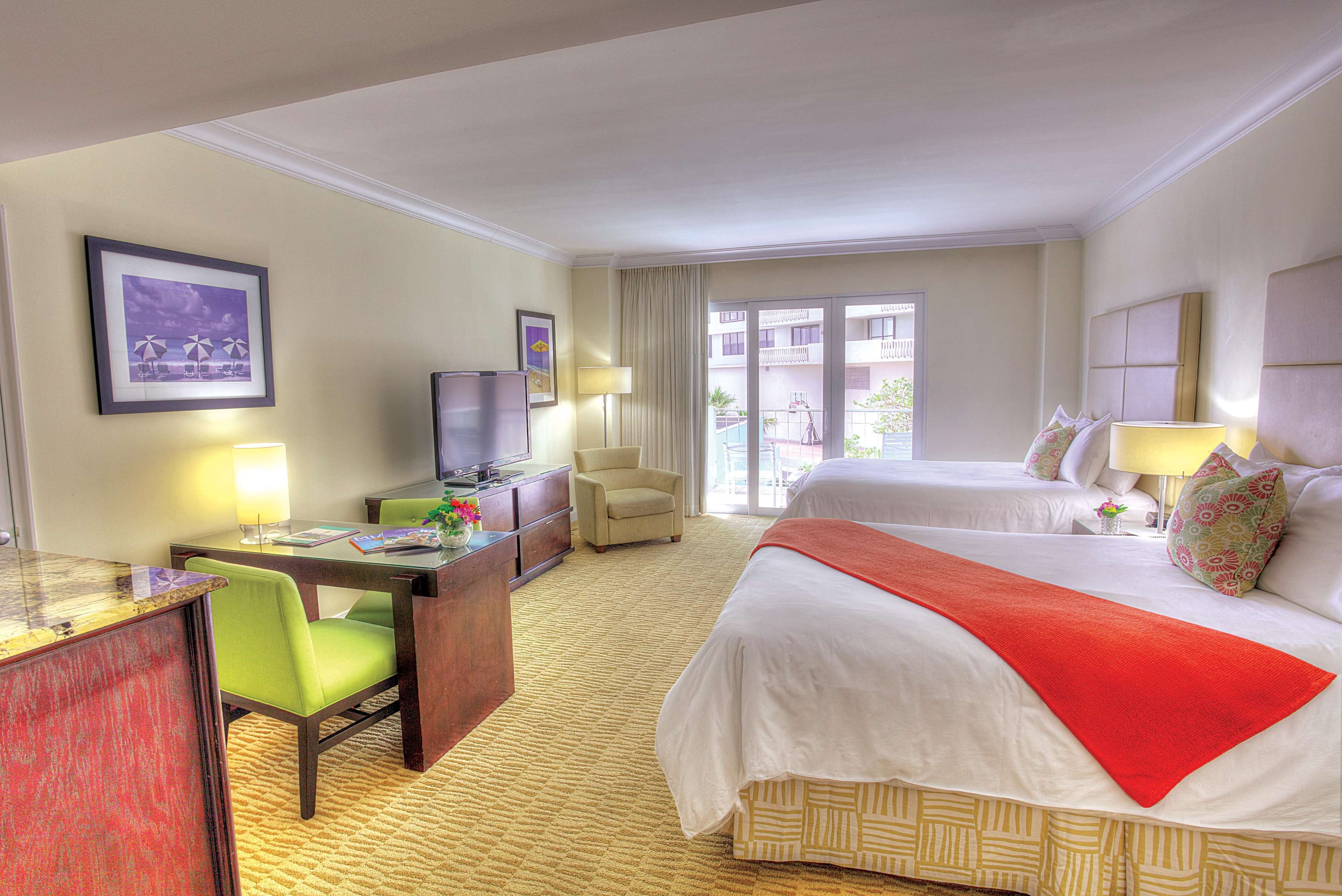 Ein Hotelzimmer mit Bett, Schreibtisch, Stuhl, Fernseher und einem Fenster mit Ausblick.