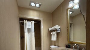 A bathroom with a shower, toilet, sink, and vanity. - Windsor Inn Hotel (Washington)