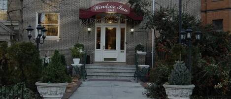 Windsor Inn, a brick building with a classic facade, a central entrance with steps, and a sign indicating the year 1842.