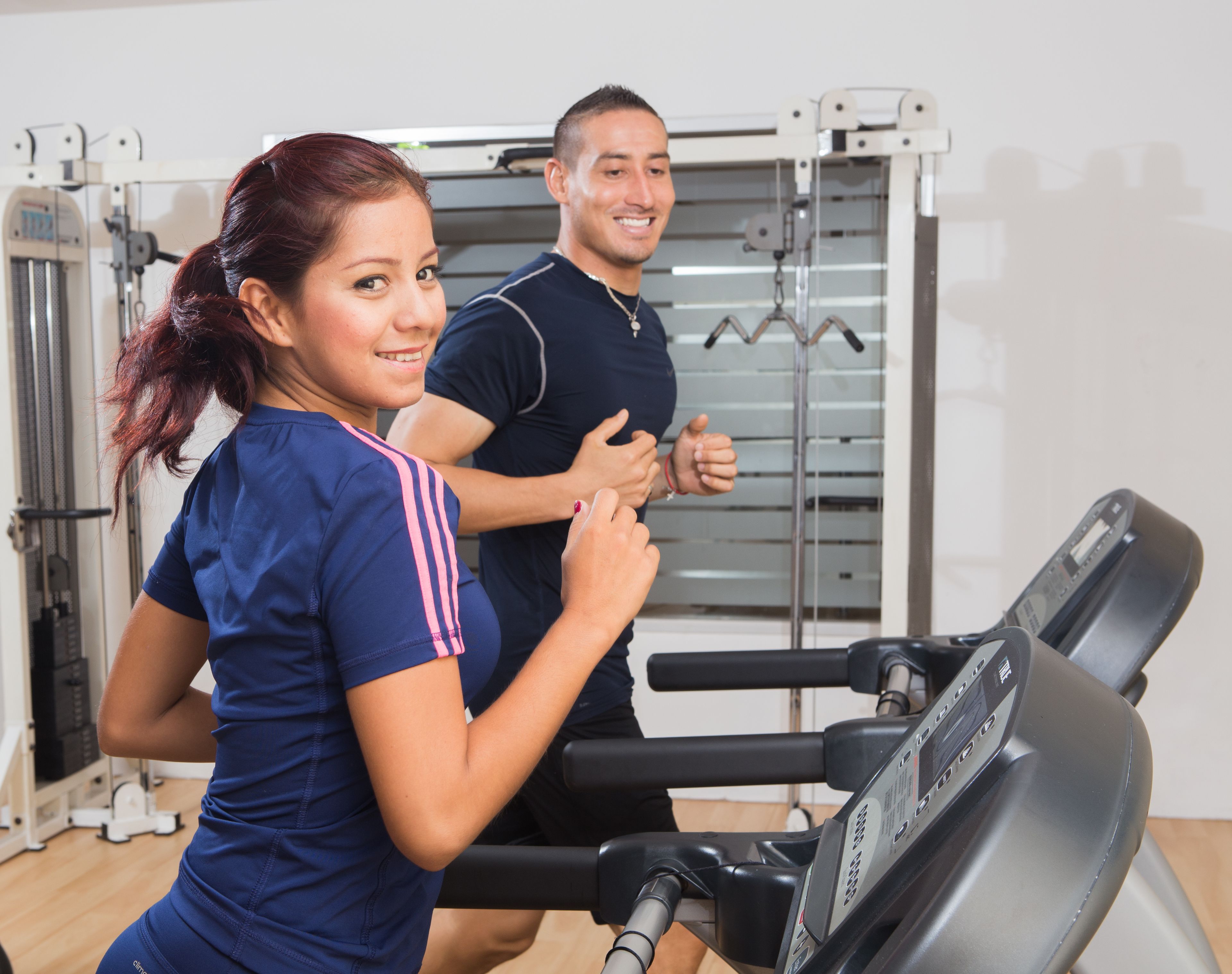 Une salle de sport équipée de matériel d’exercice, notamment un tapis de course et des appareils de musculation.