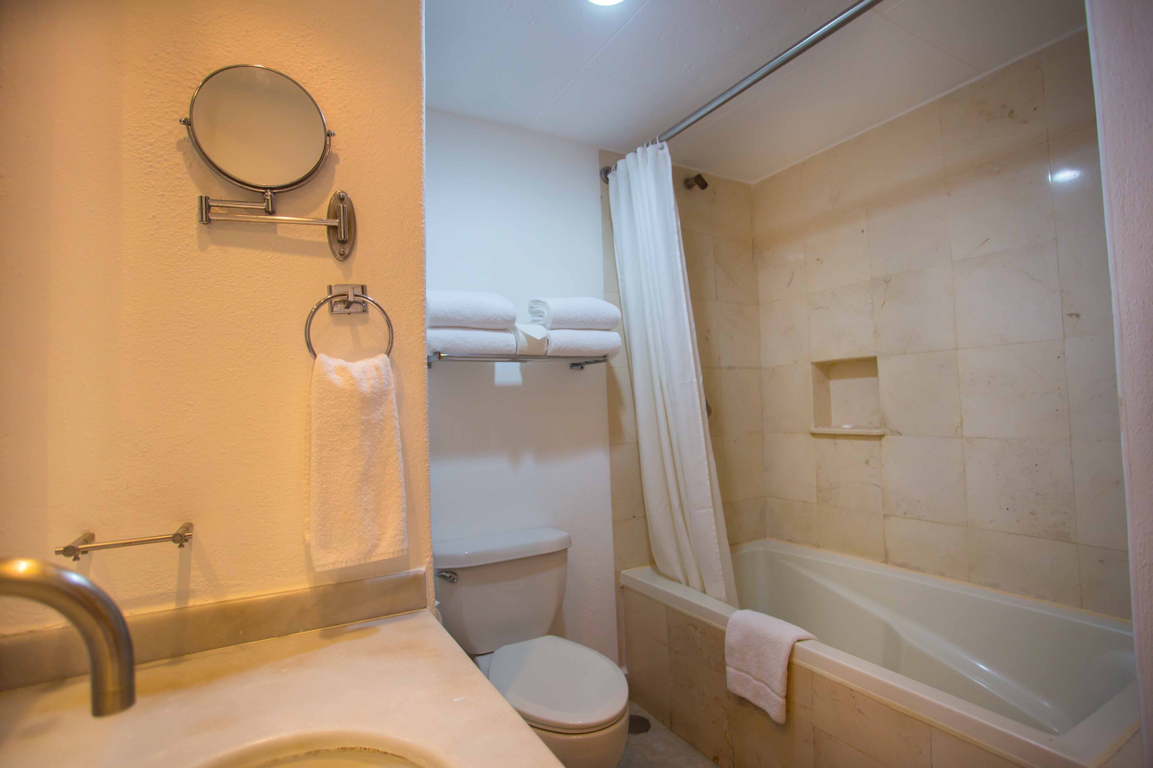 A bathroom with a toilet, sink, and bathtub.