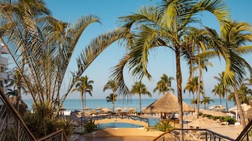 Ein Resort mit Pool, Palmen und Strandliegen.