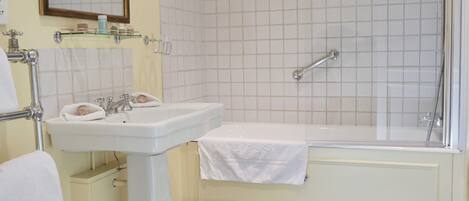 Un baño con lavamanos pedestal, bañera, inodoro y ducha.
