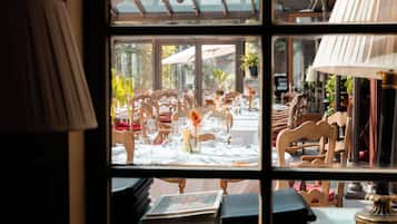 A room with a large window, wooden furniture, and a table set for dining.