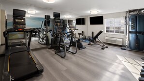 A gym with treadmills, elliptical machines, and weight equipment.