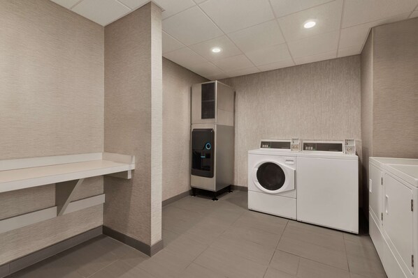 A laundry room with a washing machine, dryer, and a water dispenser.