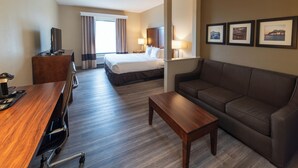 A hotel room with a bed, a sofa, a desk, and a TV. - Sonesta Essential - Baton Rouge Airport (Baton Rouge)