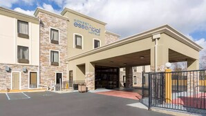 A Sonesta Essential Hotel with a stone facade, a covered entrance, and a parking lot. - Sonesta Essential - Baton Rouge Airport (Baton Rouge)