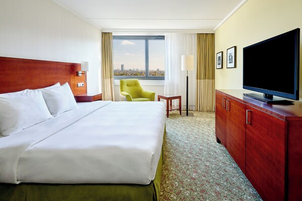 Relax in a spacious room with a large bed, flat-screen TV, and city views.
