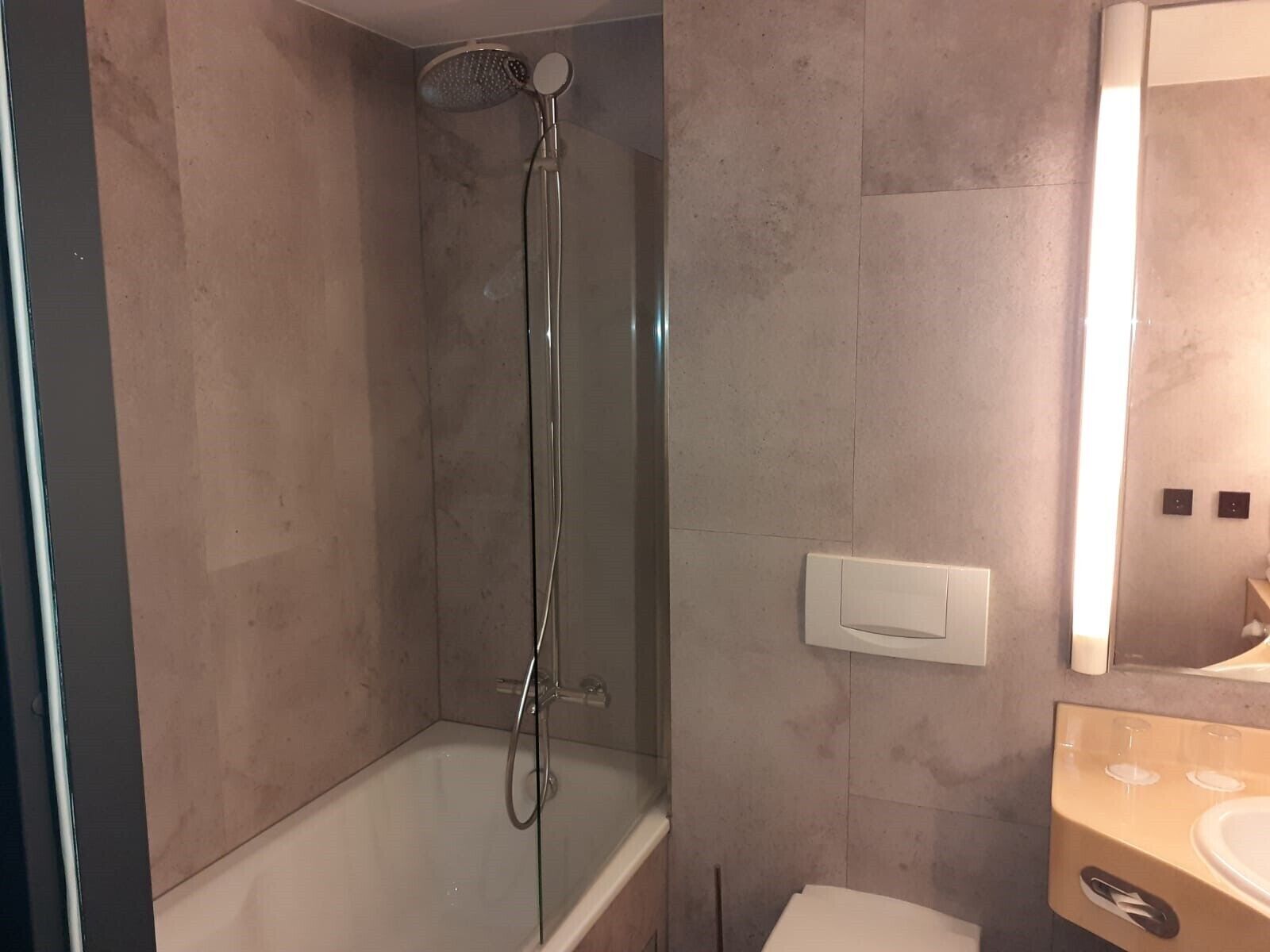 A modern bathroom with a bathtub, a shower, and a vanity with a mirror.