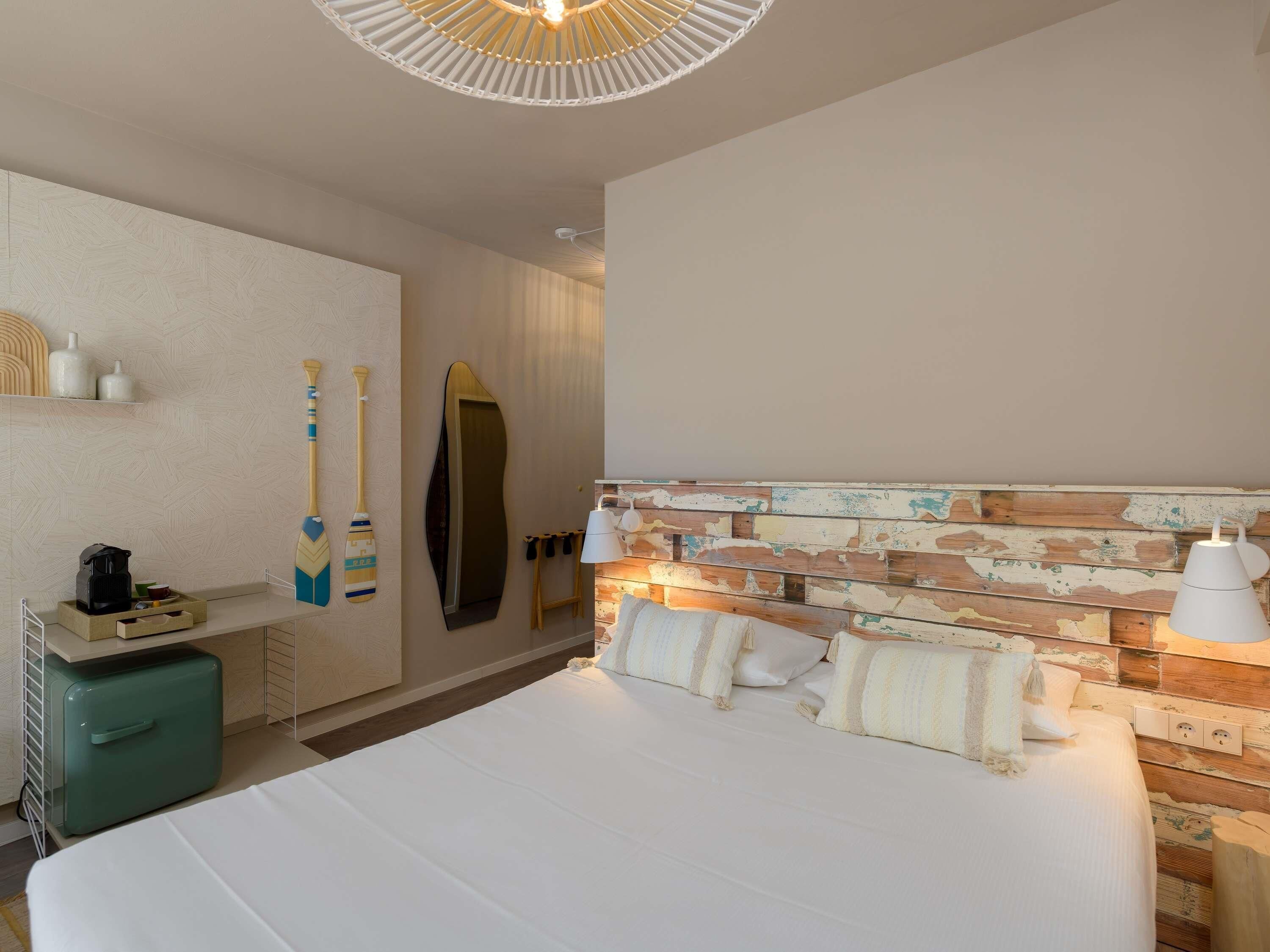 Ein Hotelzimmer mit einem Bett, einem Schminktisch, einem Spiegel und einer Wand mit Holzvertäfelung.