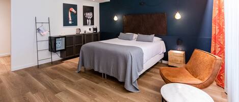 Un dormitorio moderno con una cama grande, mesitas de noche, un escritorio y una silla.