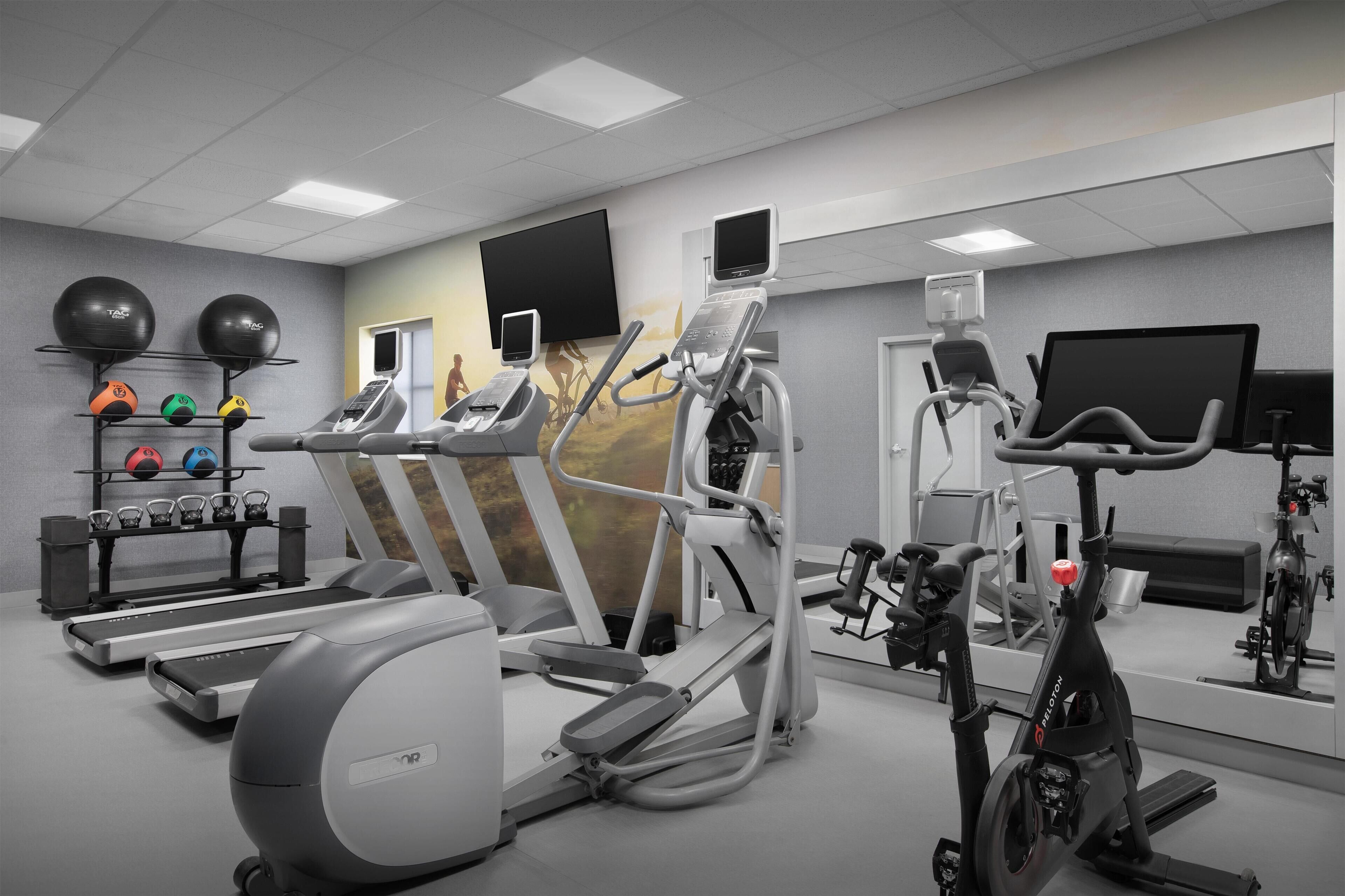A gym with treadmills, elliptical machines, and stationary bikes.