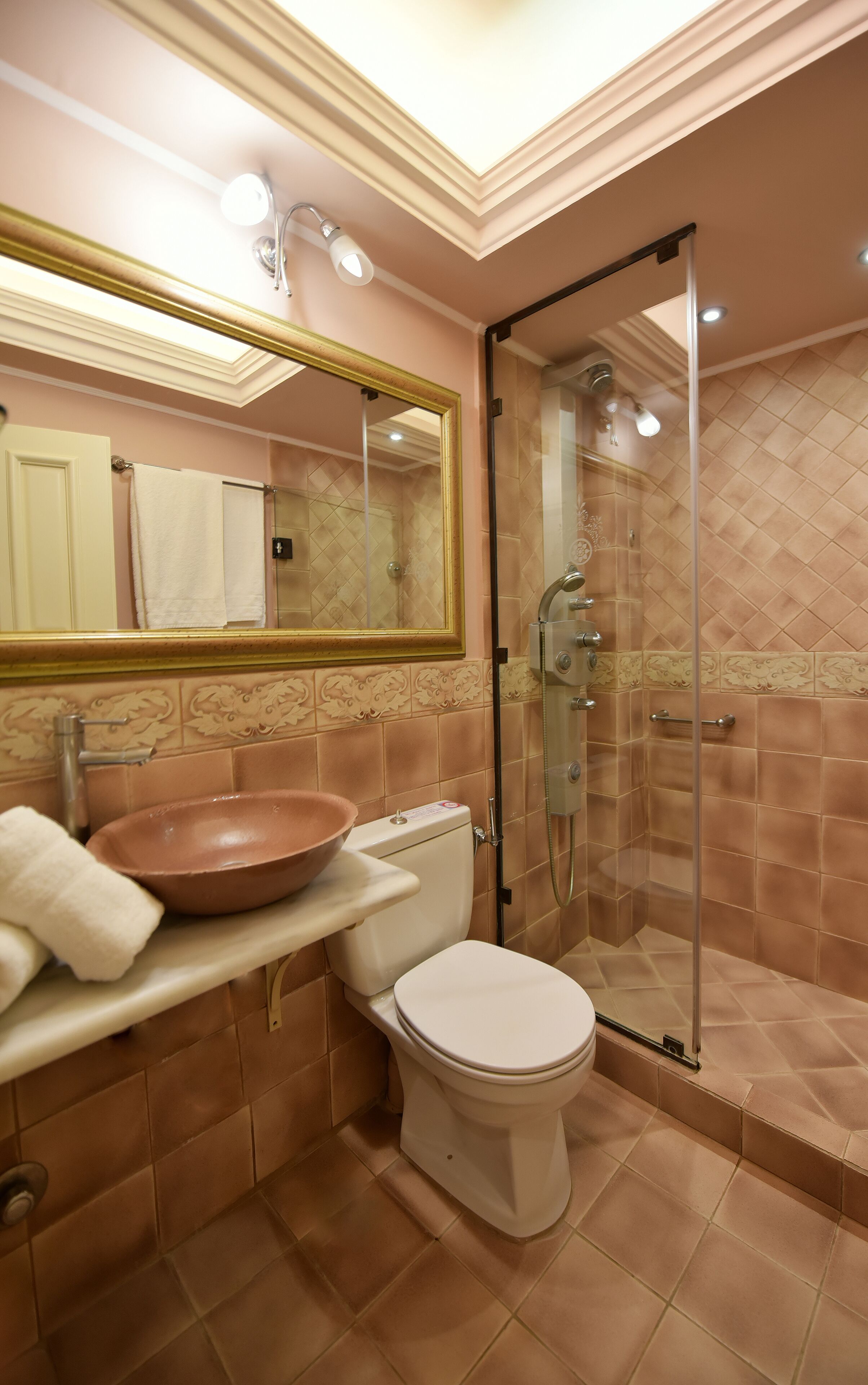Ein Badezimmer mit großem Spiegel, Waschbecken, Toilette und einer Duschkabine.