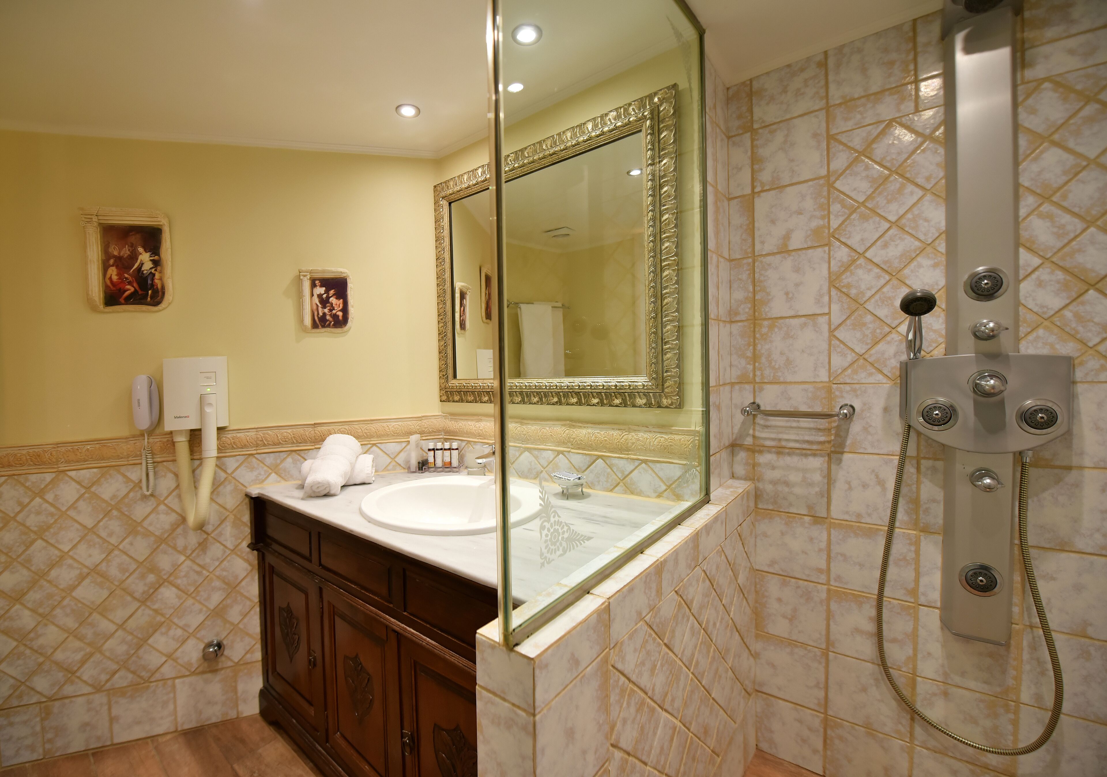 Un baño con un espejo grande, un lavamanos y una ducha.