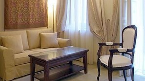Una sala de estar con un sofá, una mesa de centro de madera y un sillón.