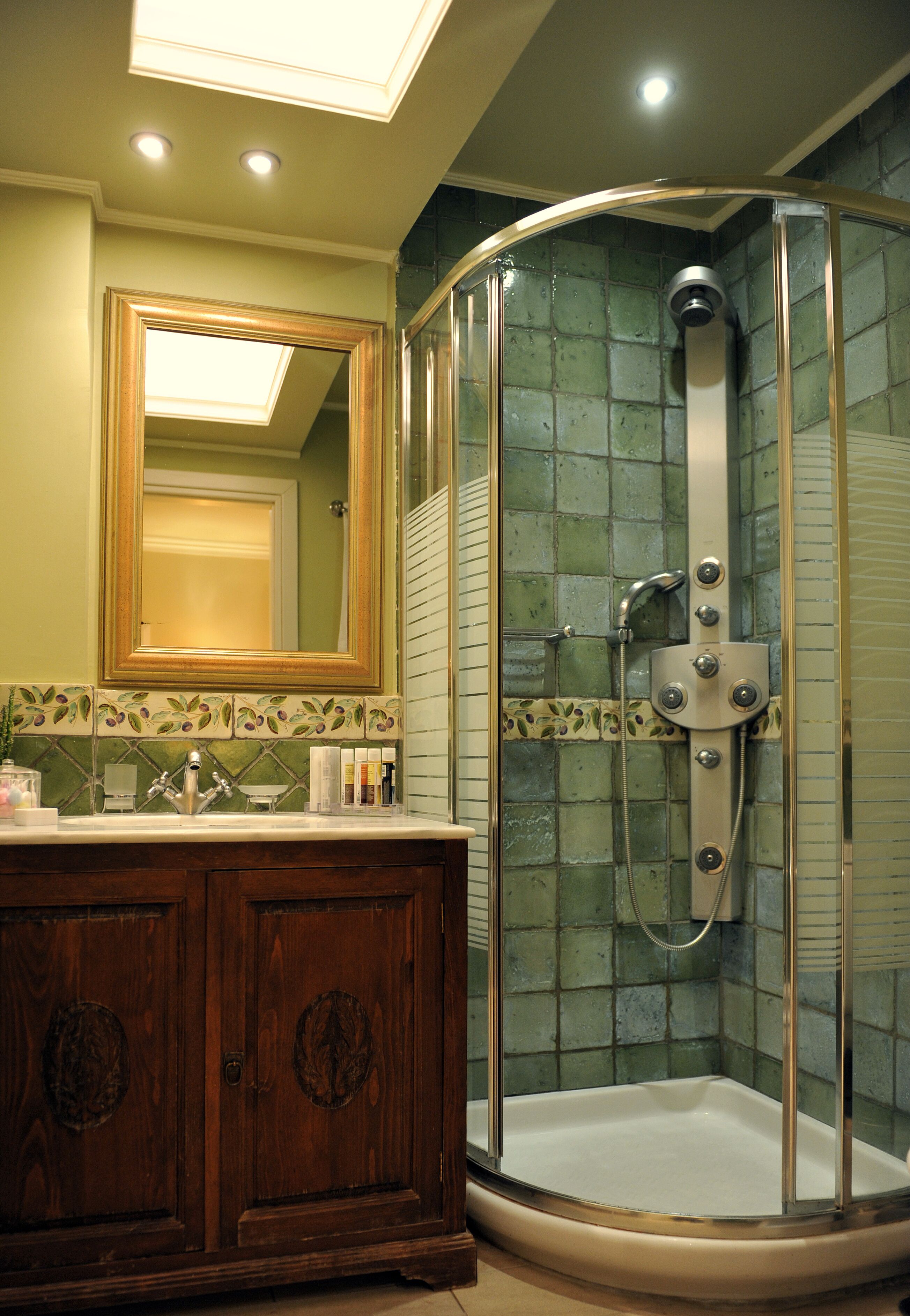 A bathroom with a glass-enclosed shower, a wooden vanity, and a large mirror.
